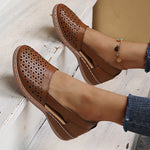 Brown round-toe wedge sandals with laser-cut side panels and ankle strap