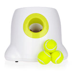 White automatic dog ball launcher with lime-green ball chute and three neon tennis balls