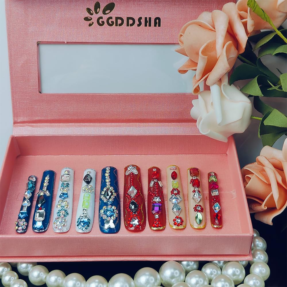 Long press-on nails with multicolor rhinestones, stars and butterfly accents in blue and red