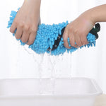 Blue microfiber pet bath towel held over water for quick-drying, paw pattern side