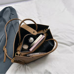 Open tan textured PU bucket tote bag showing interior pocket and zipper opening.