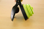 Foldable pet waste scooper with black grip and green folded scoop