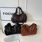 Women’s retro PU handbags on display, black and brown colors, with top handles and straps.