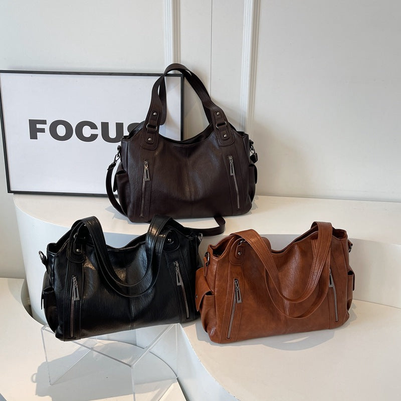 Women’s retro PU handbags on display, black and brown colors, with top handles and straps.
