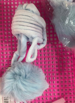 Furry light-blue pom ball on a white spring cover for cat toy