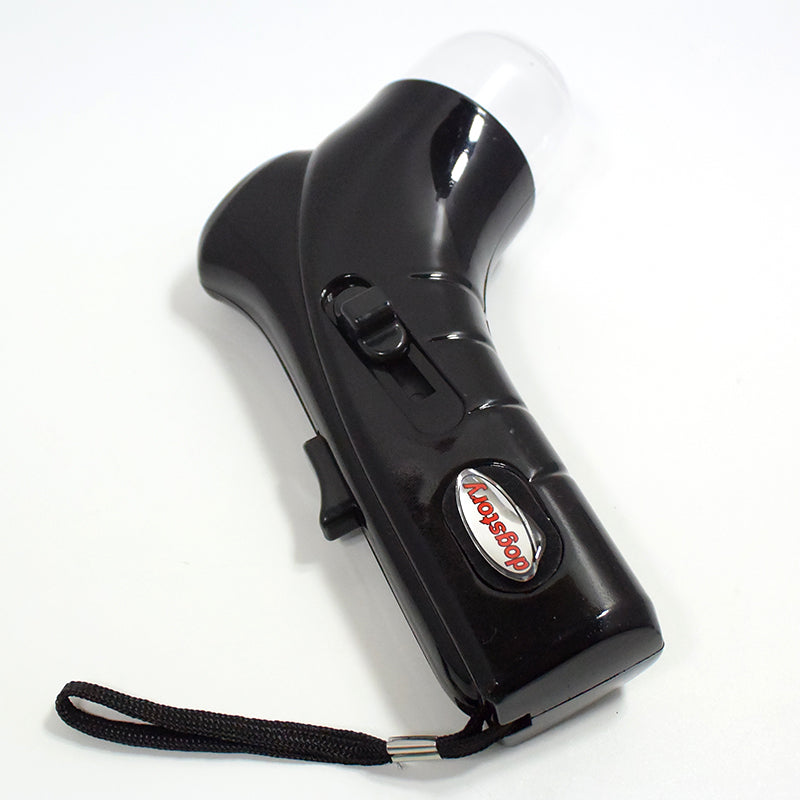 Black treat launcher toy with clear front dome and black trigger switch, close-up.