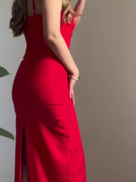 Red fitted maxi slip dress with spaghetti straps and front slit detail.