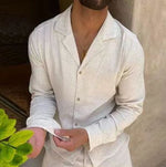 White long-sleeve lapel shirt with button placket and slim matching trousers, close-up.