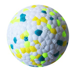 Textured dog chew ball close-up with neon multicolor shapes on white