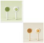 Set of two cat grooming comb brushes, green and cream, with spiked paw heads