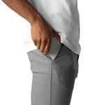 Gray slim-fit trousers pocket detail with hand, button waistband, straight legs