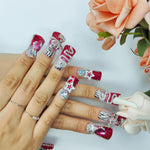 Medium square nails on hands with red and silver glitter tips, rhinestones, stars and heart accents