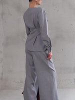 Light gray V-neck button top with wide-leg pants, side view