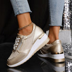 Women's gold lace-up sneakers with side zip, thick white sole and ankle chain detail