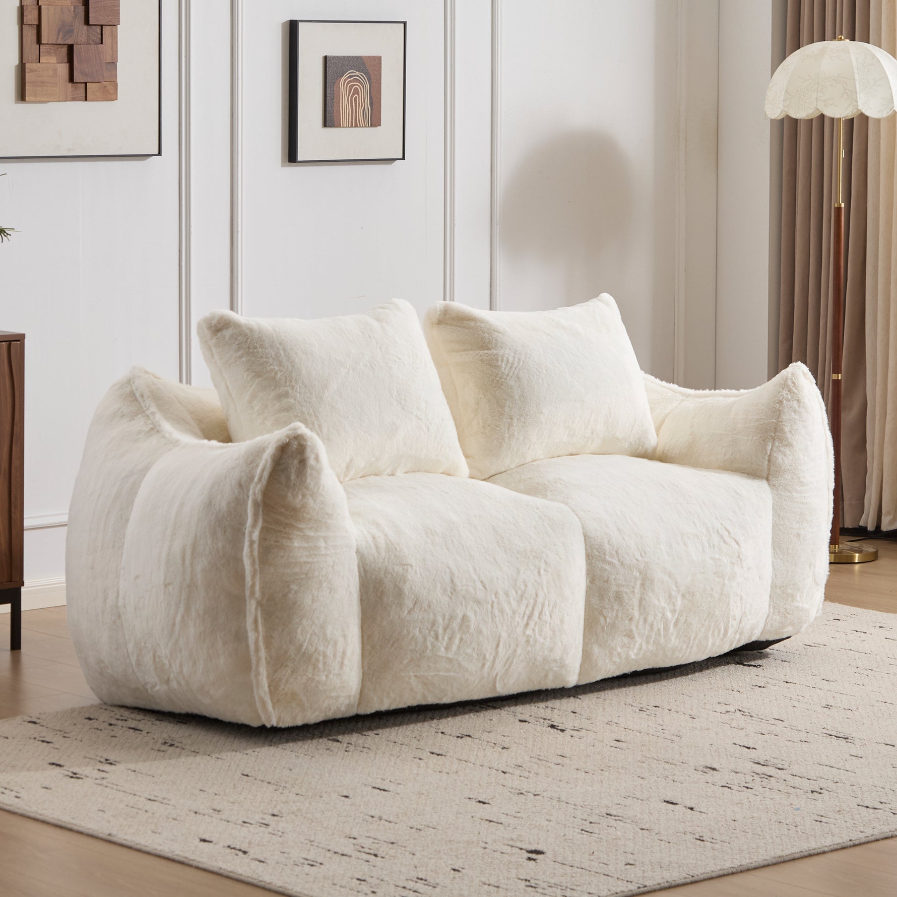 White plush bean bag loveseat sofa with three pillows and rounded armrests