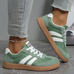 Casual sneakers in green with white side stripes and tan rubber sole