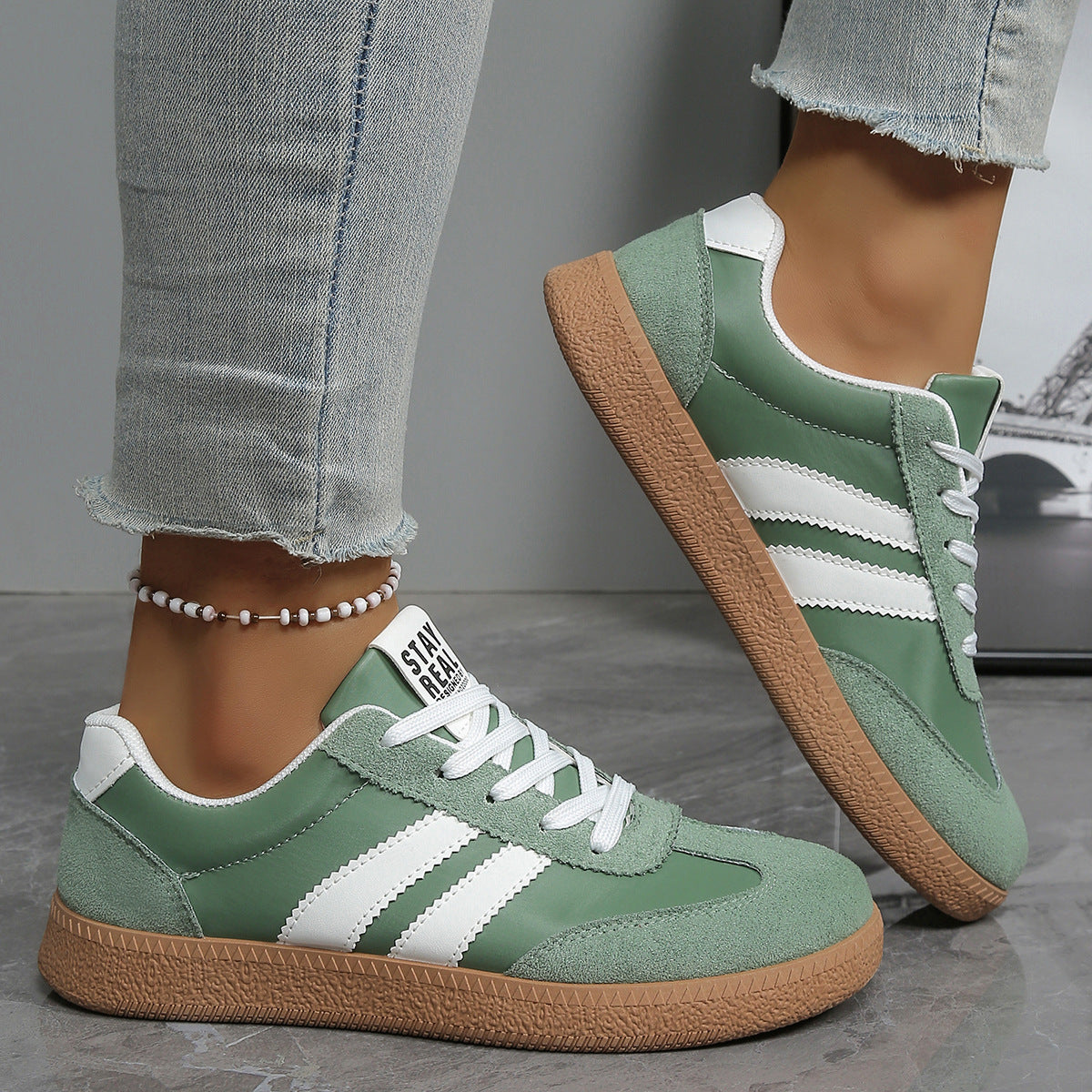 Casual sneakers in green with white side stripes and tan rubber sole, lace-up