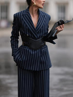 Navy pinstripe blazer with deep V front and black belt over matching wide-leg pants