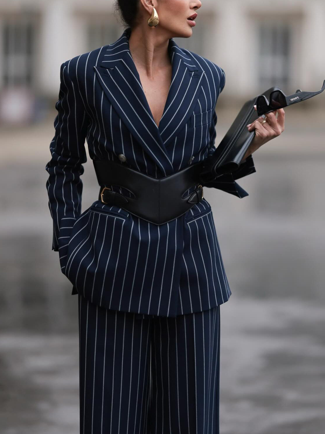 Navy pinstripe blazer with deep V front and black belt over matching wide-leg pants