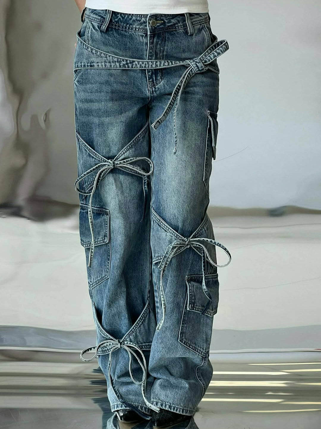 Denim utility jeans with multiple patch pockets, diagonal strap and knot-tied cords, blue