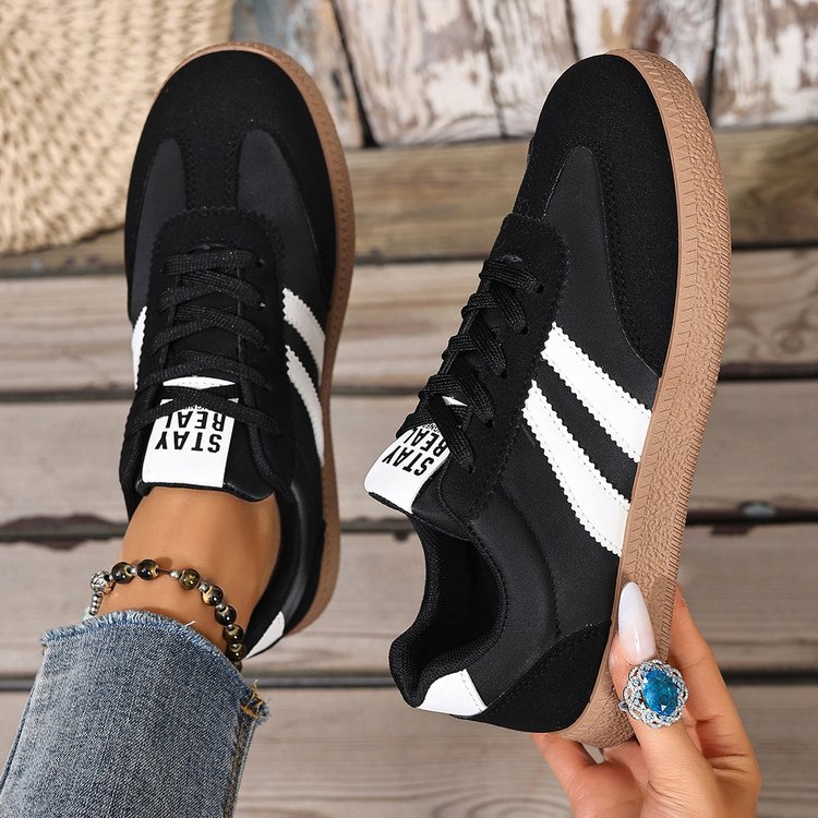 Casual sneakers in black with white side stripes and tan rubber sole