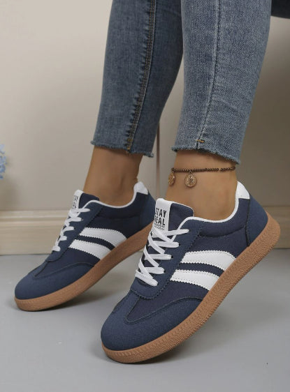 Casual sneakers in dark blue with white side stripes and tan rubber sole
