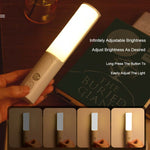 Handheld LED night light with glowing vertical lamp tube and side brightness button, gray finish