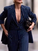 Navy pinstripe blazer with deep V neckline and button front over wide-leg pants