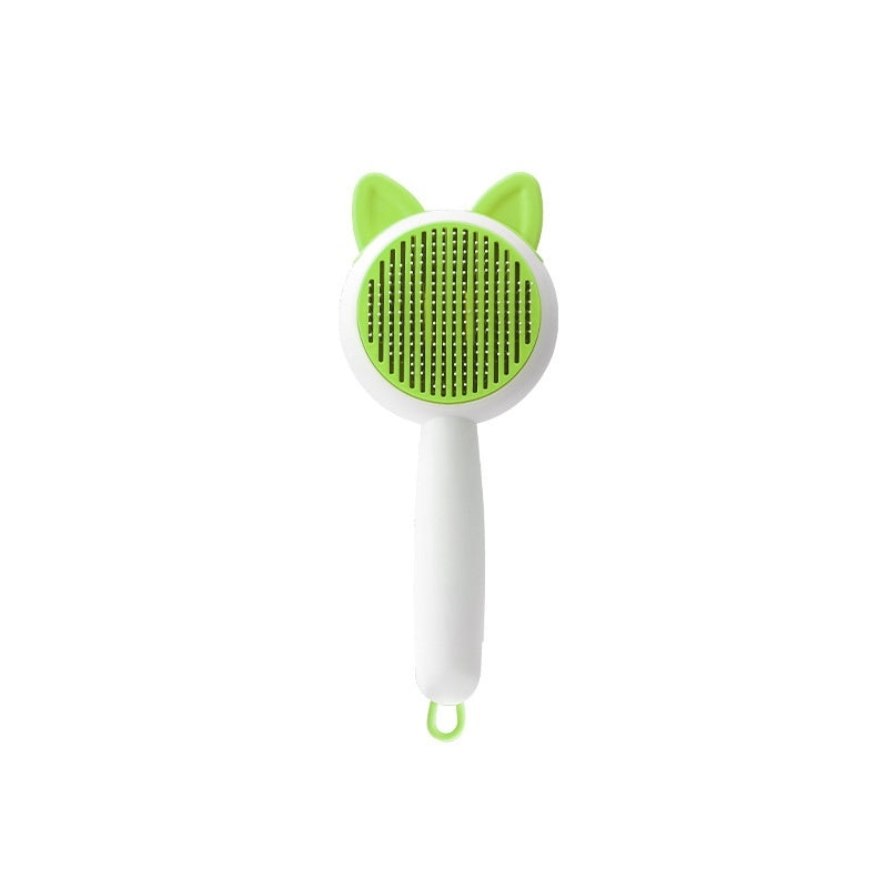 Self-cleaning pet grooming brush with green bristle pad, white handle, and cat-ear grip