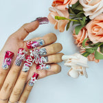 Medium square nails with red and silver glitter, crystal accents, stars and decorative swirls