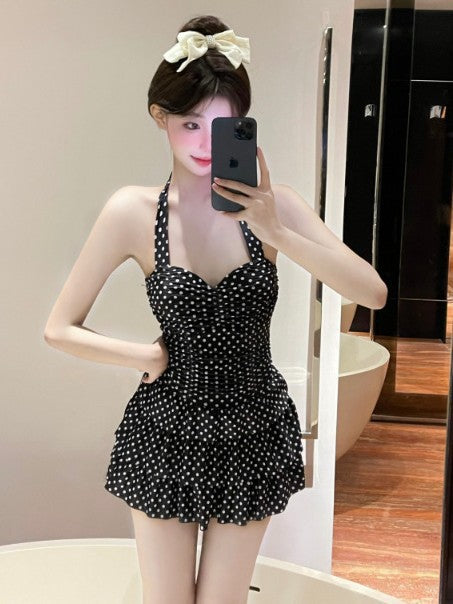 Black polka-dot one-piece skirt swimsuit with ruched bust and tiered ruffle skirt