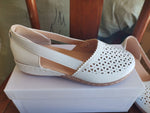 White round-toe wedge sandals with laser-cut side panels and stitched sole