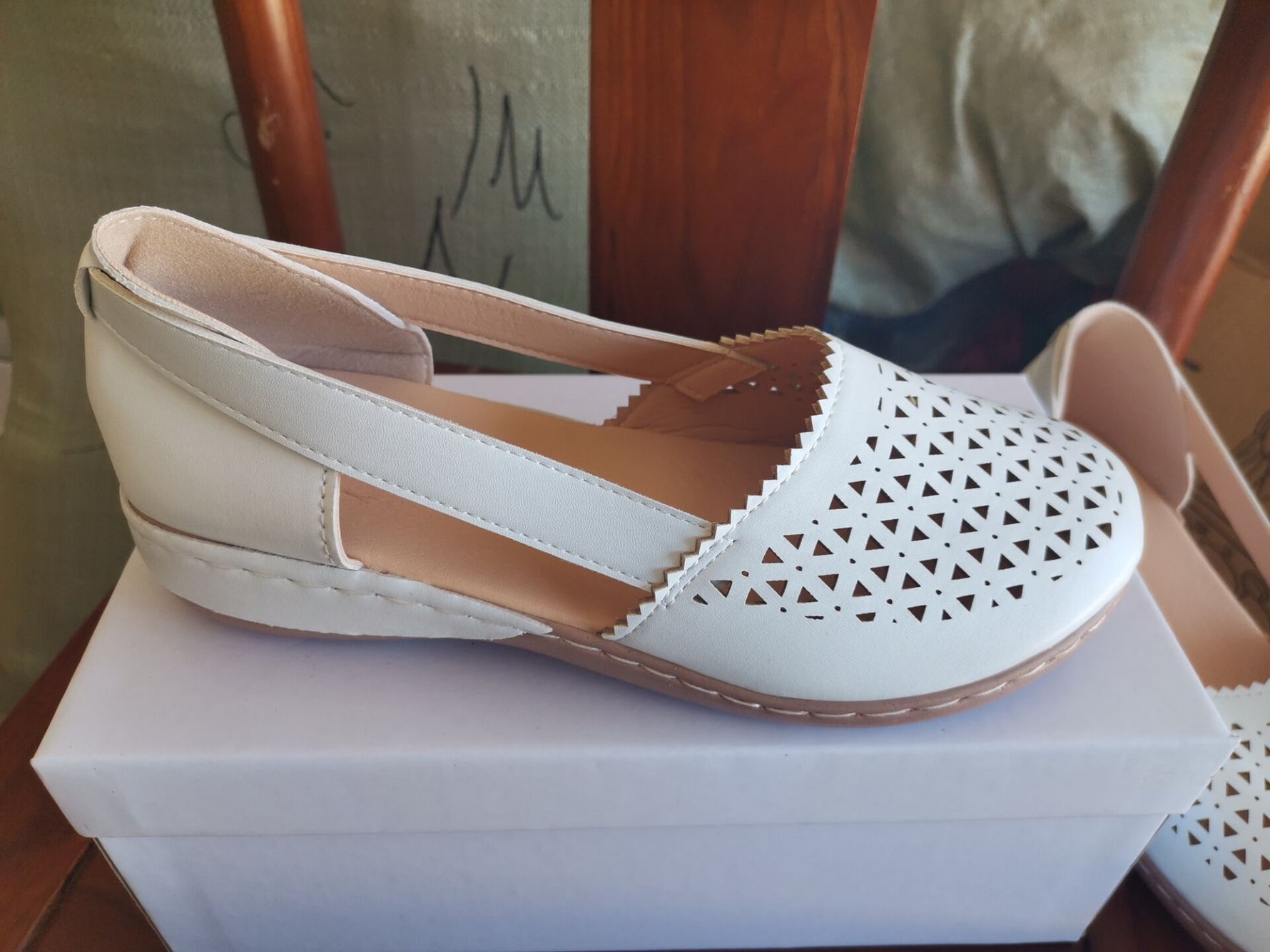 White round-toe wedge sandals with laser-cut side panels and stitched sole