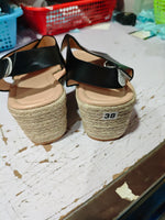 Open-toe wedge sandals with crisscross straps, black PU and tan espadrille platform, rear view