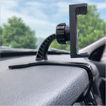 Car dashboard phone holder clip gripping a textured dash, black plastic mount