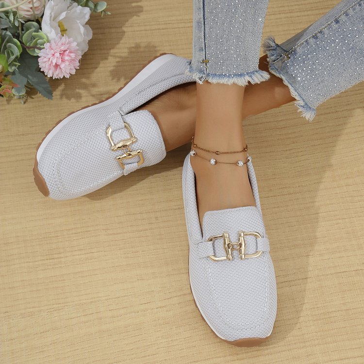 White women’s canvas flat sneakers with gold horsebit-style detail and raised collar.