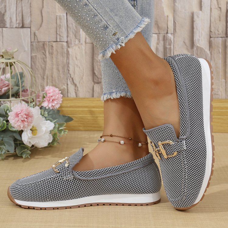 Dark women’s mesh canvas slip-on sneakers with gold horsebit-style detail and white sole.