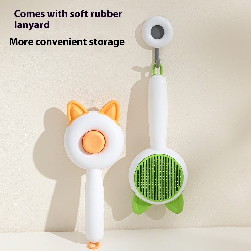 Self-cleaning pet brush with lanyard loop and green bristle pad, cat-ear handle