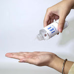 Tunmate toner bottle with flip-top nozzle above open palm, clear drop dispenser