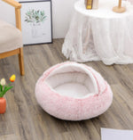 Round pink plush pet bed, open nest with thick padded rim