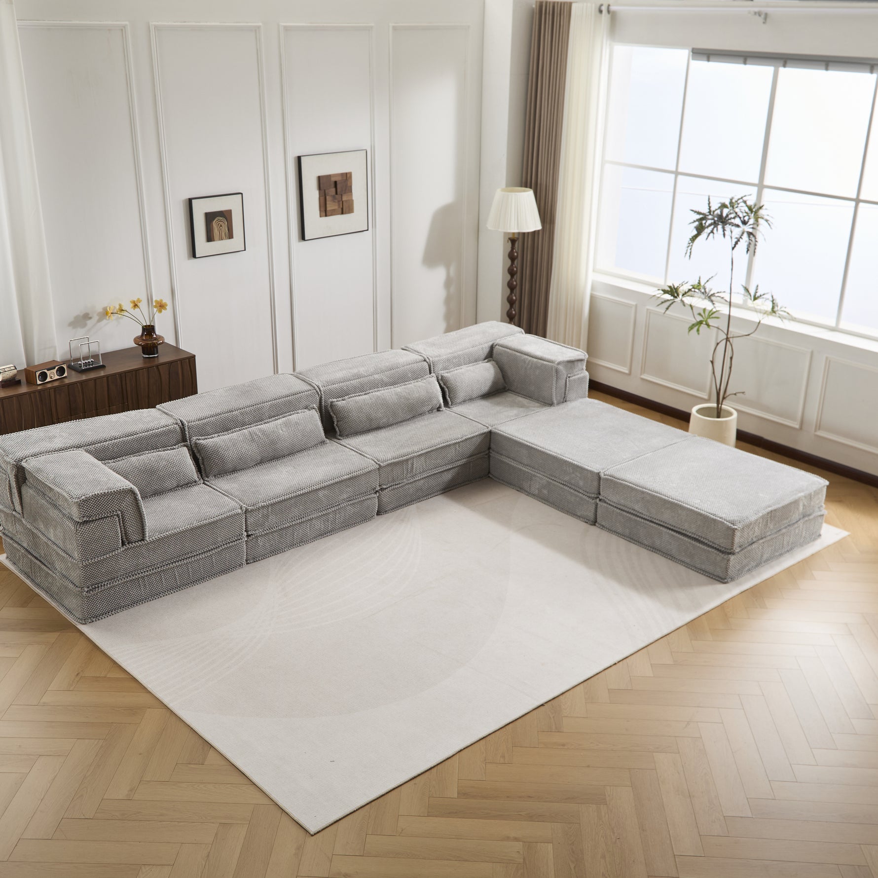 Light grey modular sectional sofa with ottomans, extended chaise corner view