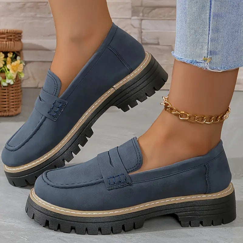 Women’s matte dark blue flat loafer shoes with round toe, buckle strap, and thick tread sole