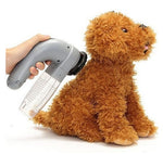 Portable pet hair vacuum cleaner brushing a curly dog with silicone bristle head