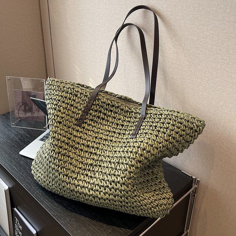 Woven shoulder beach bag in olive green with black straps and top handle detail