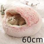 Round pink shag plush pet bed with cat resting inside curved opening