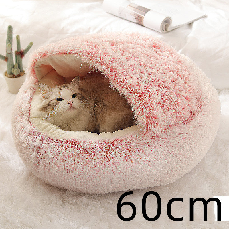 Round pink shag plush pet bed with cat resting inside curved opening