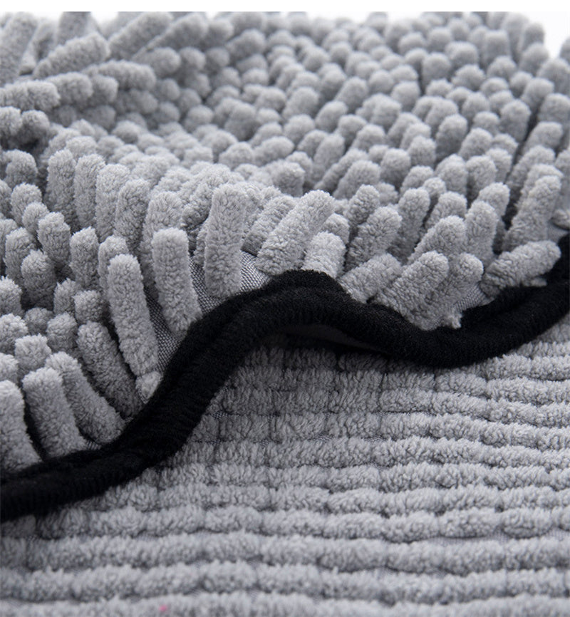Close-up of gray microfiber bath towel with shaggy loop pile and black-edged seam