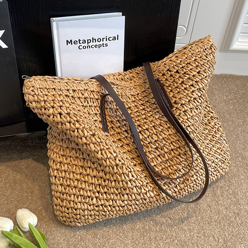 Woven shoulder beach bag in straw beige with dark brown top handles and strap