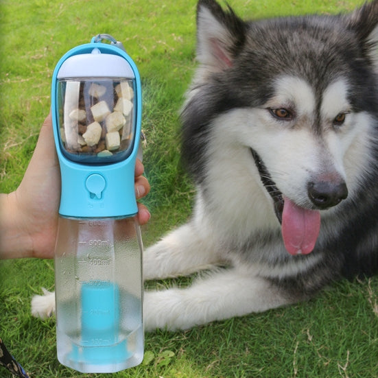 Portable dog water bottle with blue cup lid, held near a lying husky outdoors