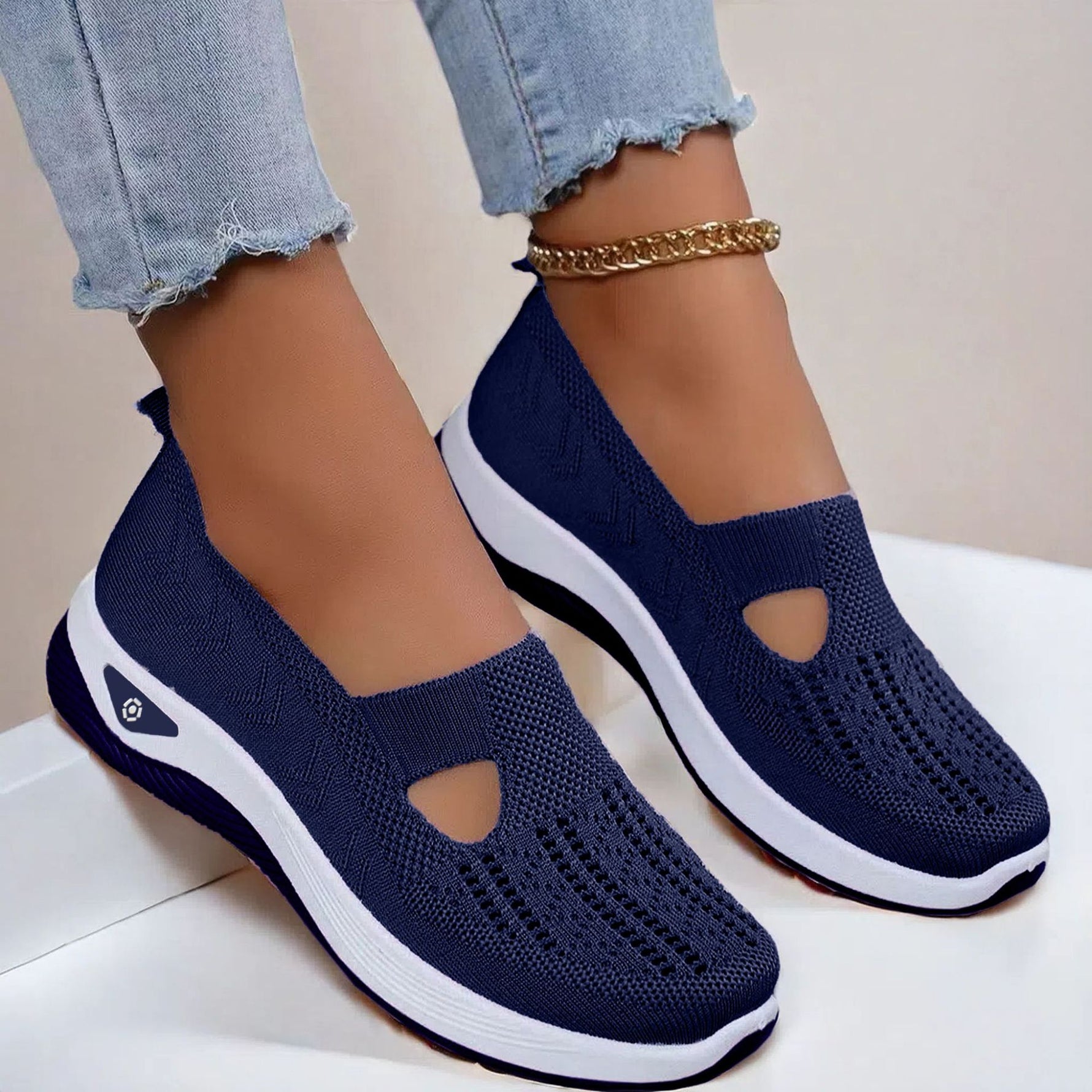 Navy blue mesh slip-on flat shoes with oval cutouts and white cushioned soles